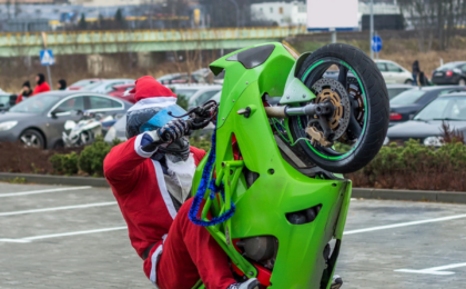 Der Weihnachtsmann fährt auf dem Hinterrad auf einem Motorrad